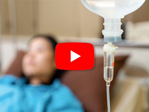 Mulher deitada em uma cama de hospital recebendo soro intravenoso.