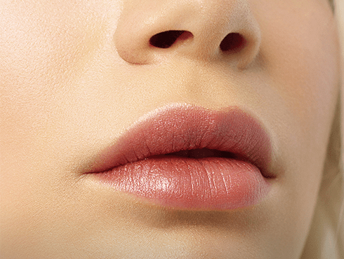 Close-up de lábios hidratados e bem definidos, com aparência natural e saudável, destacando textura suave e brilho sutil.